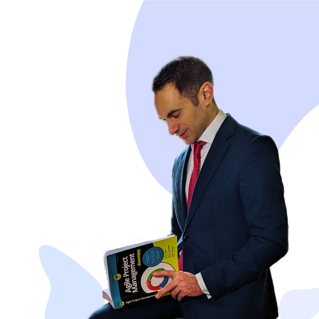 A freelance e-commerce project manager, smartly dressed, reads from a book titled: Agile Project Management for Dummies