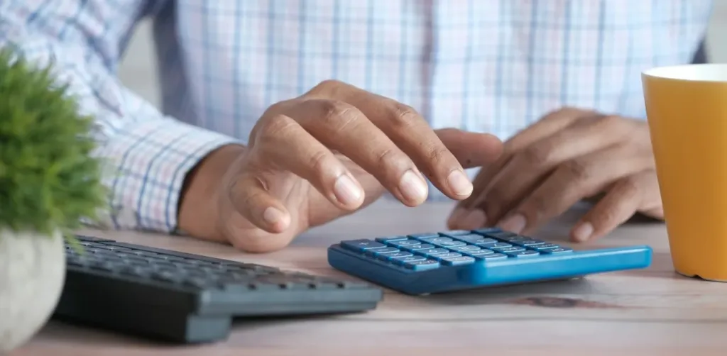 A man typing on a calculator