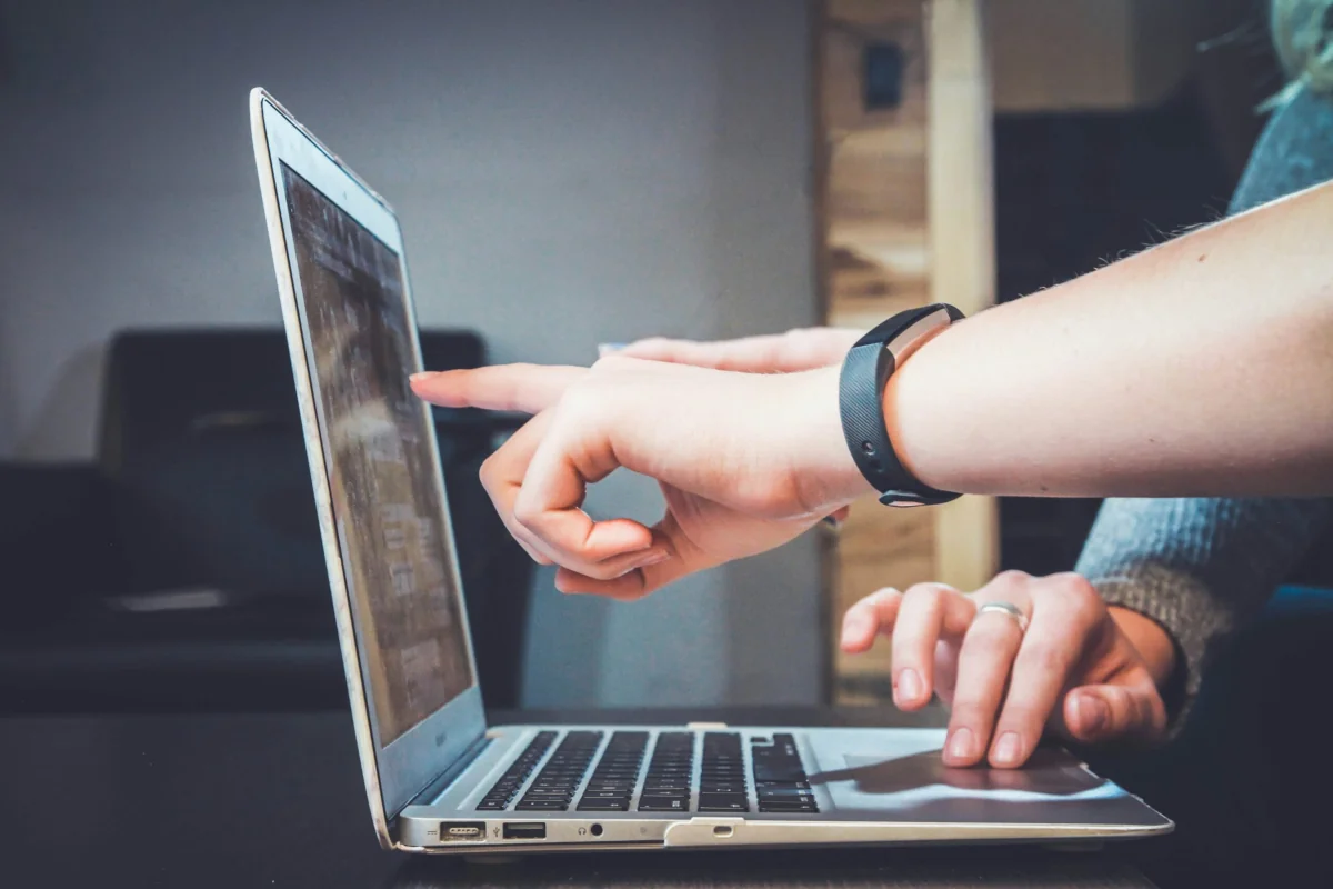 picture by John Schnobrich from Unsplash of a person pointing to a macbook laptop screen